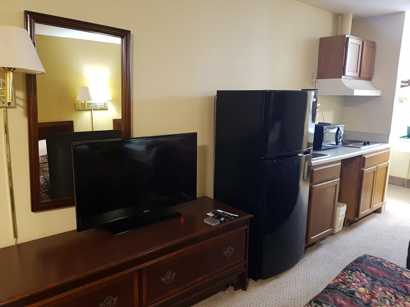 TV, dresser, refrigerator, and in-room kitchenette